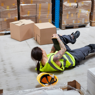 an injured warehouse worker lying on the floor after an injury