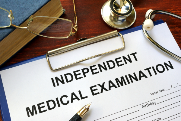 Independent Medical Examination (IME) form on a wooden table